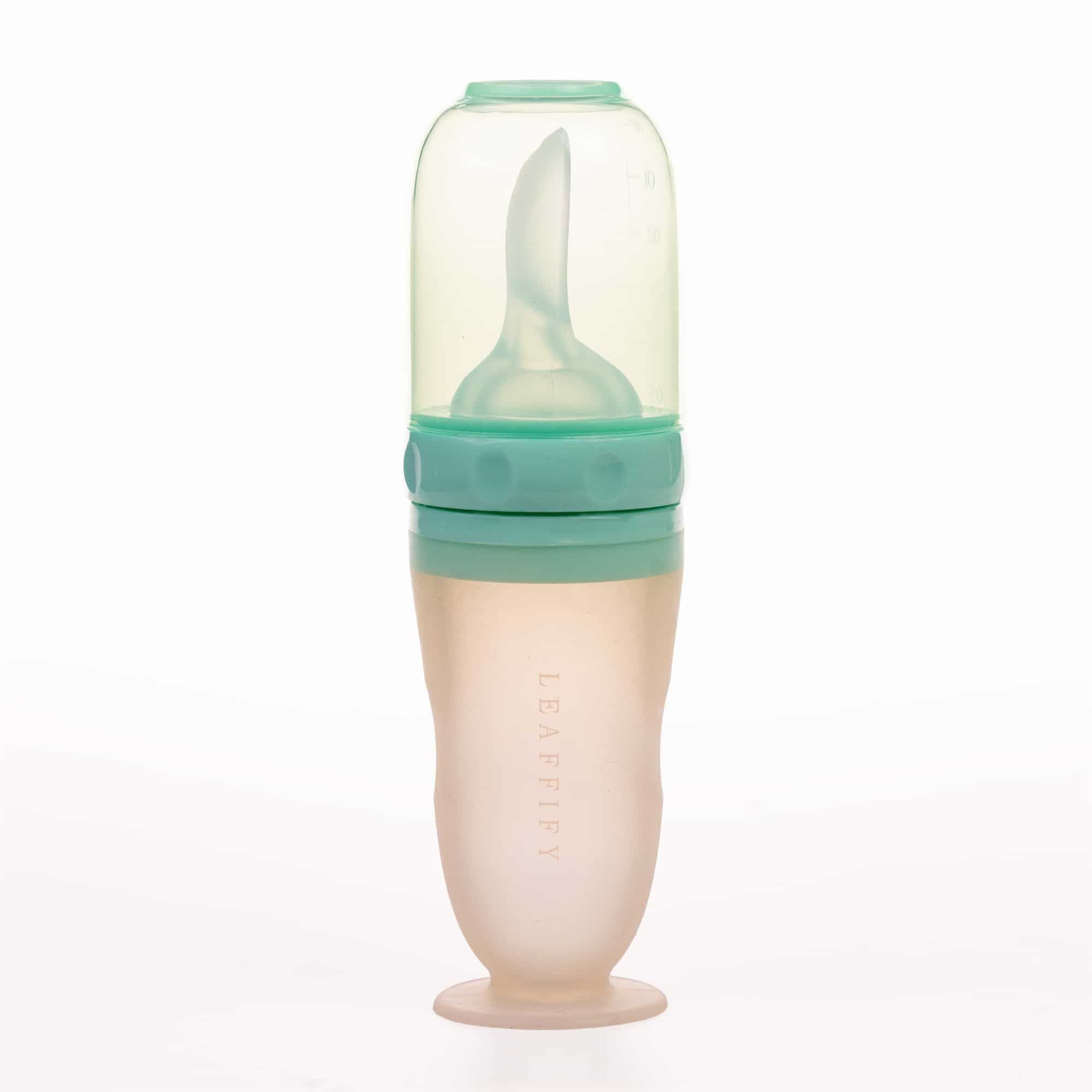 Productfotografie: LEAFFIFY logo midden op groene fles. Babyvoeding fles met lepel.