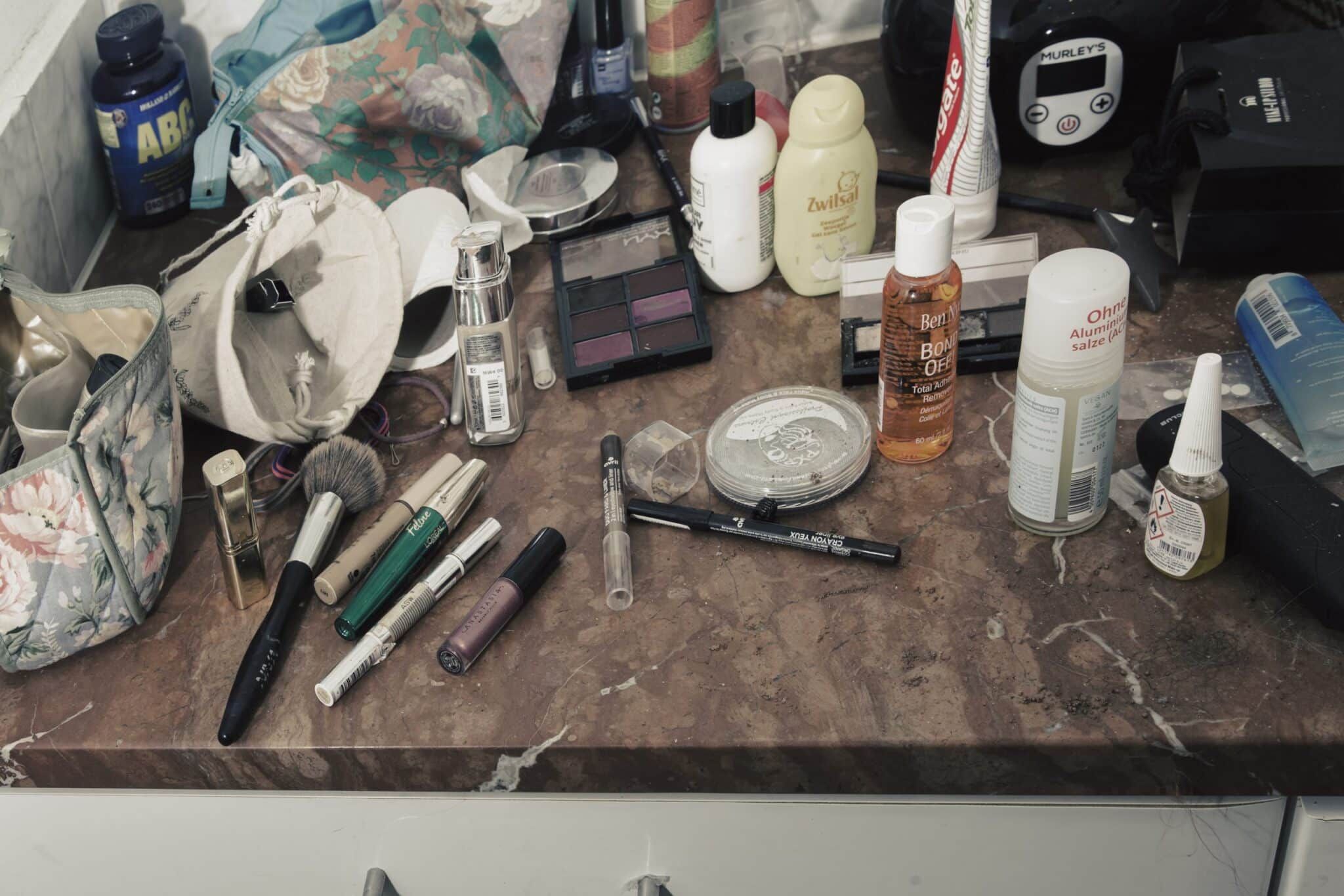 Foto van een tafel vol make-up en toiletartikelen, rommelig uitgestald voor een documentaire. Autonoom georganiseerd. Joep van Drunen Photography